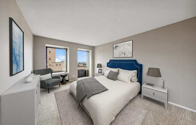 a master bedroom with a bed and a chair and a window