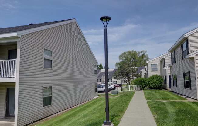 a lamp post in the middle of a sidewalk in front of houses