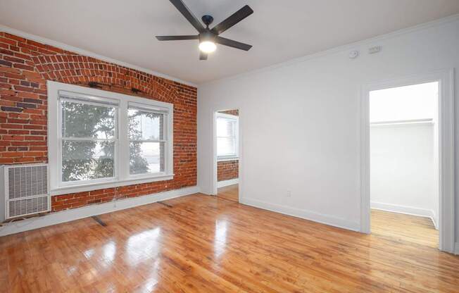 A room with a ceiling fan and wooden floors at Westmore Manor Apartments, Los Angeles, 90020