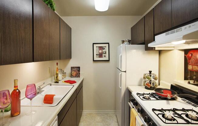Apartments for Rent in Goleta, CA- Patterson Place- White Granite Countertops With Dark Wood Cabinets And White Stove