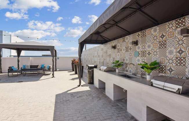 A patio with a bench and a wall with tiles.