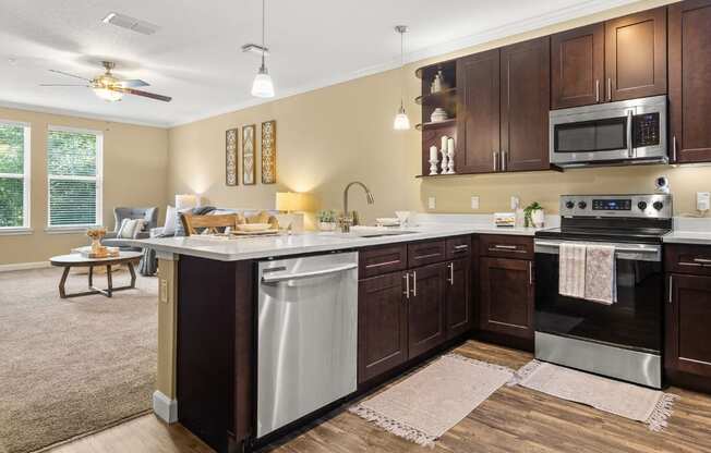 A kitchen with dark wood cabinets and stainless steel appliances.