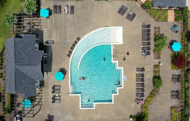 arial view of a resort pool with lounge chairs and umbrellas