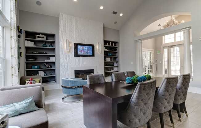 a living room with a table and chairs in front of a fireplace