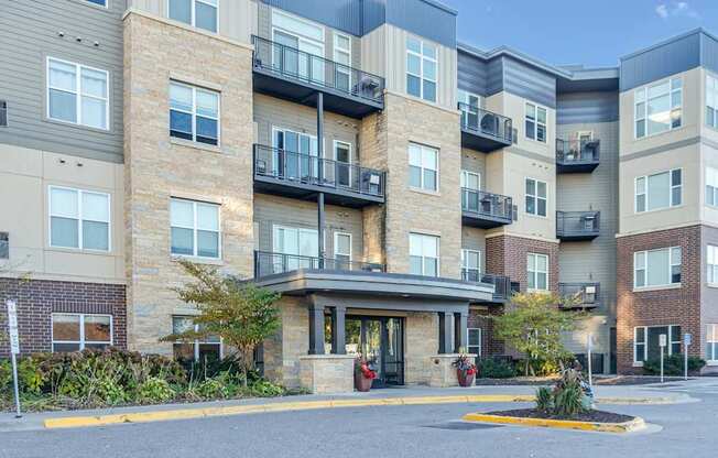 Apartment building with a parking lot in front.