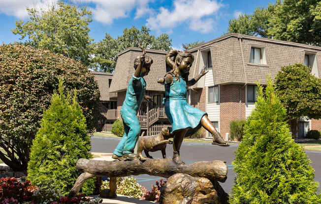 A statue of two people on a log in front of a building.