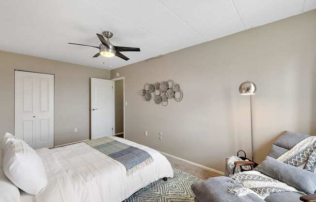 a bedroom with a bed and a ceiling fan at Troy Place Apartments - Troy, MI, Troy