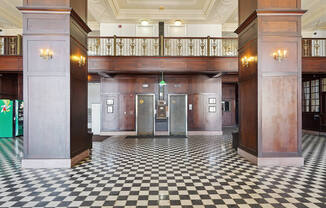 the lobby of a building with pillars and a checkered floor