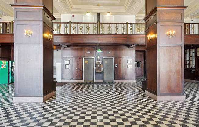 the lobby of a building with pillars and a checkered floor