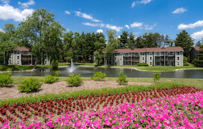 a view of a pond with flowers in front of a building