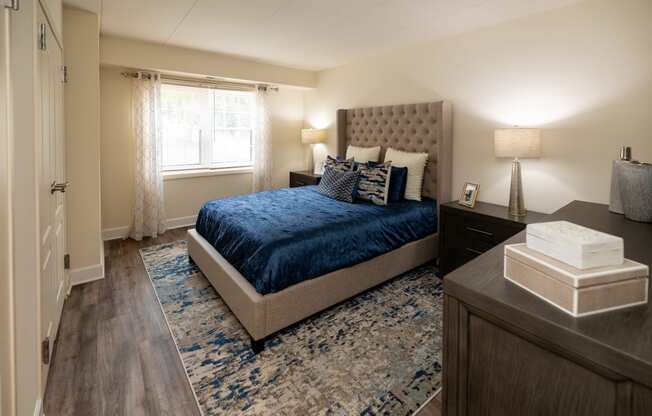 a bedroom with a bed and a dresser and a window