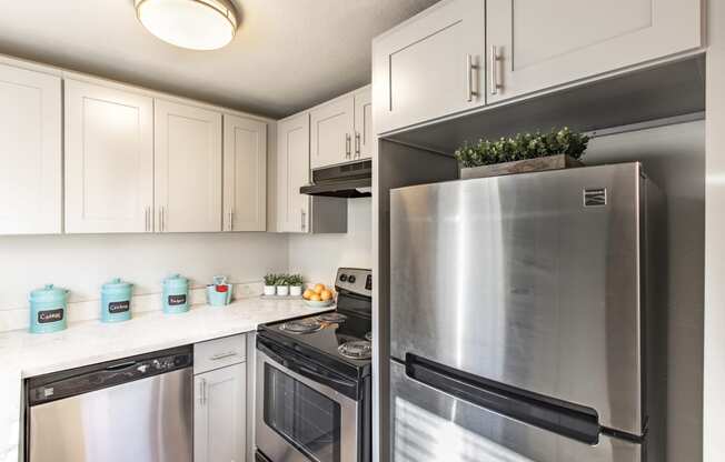 Kitchen in community lounge with stainless steel appliances and new white cabinets at The Lakes Apartments, Moses Lake, WA.