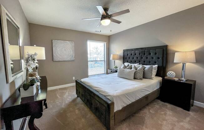 a bedroom with a large bed and a ceiling fan