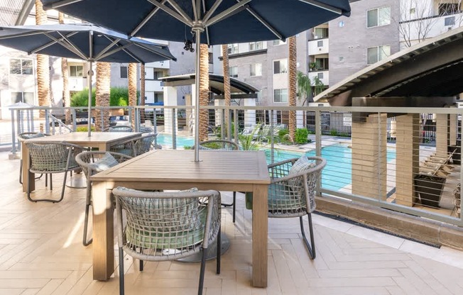 A table with chairs and umbrellas is set up on a patio.