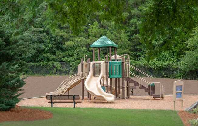 A playground with a green roofed structure and a slide.