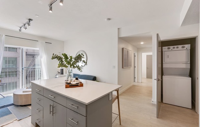 a kitchen with an island and a living room with a refrigerator