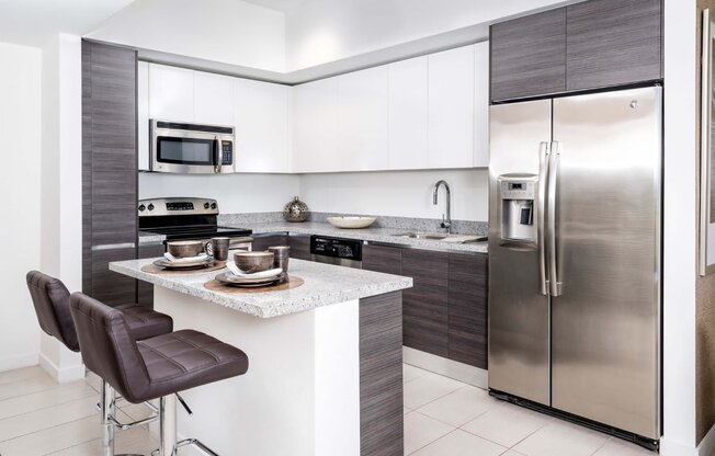 a kitchen with white cabinets and stainless steel appliances at Regatta at New River, Fort Lauderdale Florida