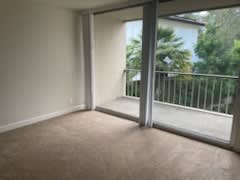 an empty living room with sliding glass doors and a balcony