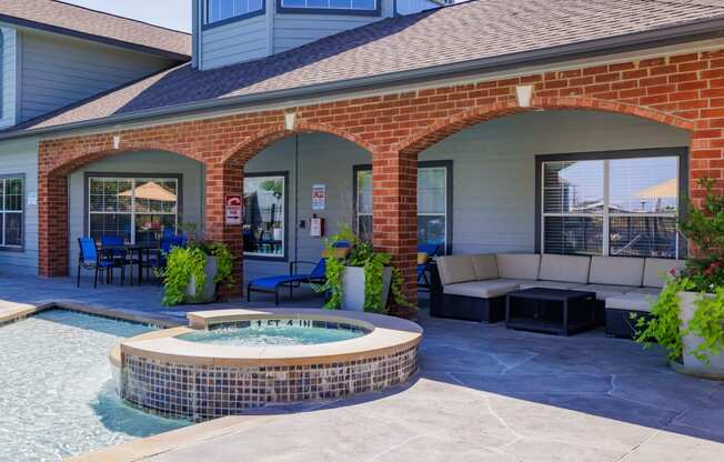 a covered patio with a hot tub and a seating area