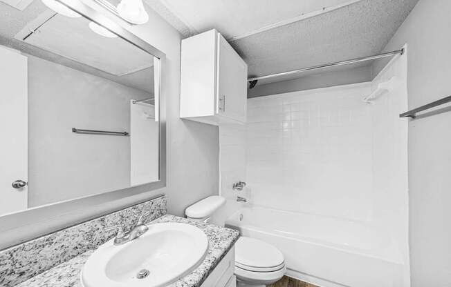 A white bathroom with a sink, toilet, and bathtub.