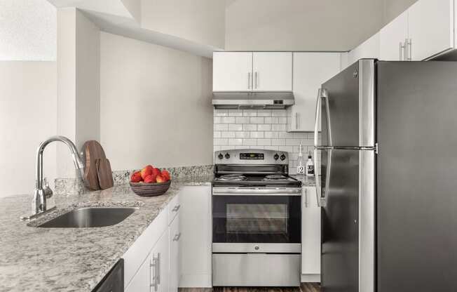 a kitchen with stainless steel appliances and granite counter tops at Arcadia Apartments, Centennial, 80112