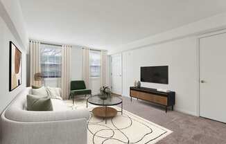 A living room with a grey couch, a green chair, a coffee table, and a television.