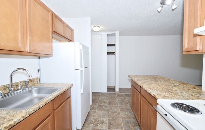 a kitchen with wooden cabinets and white appliances