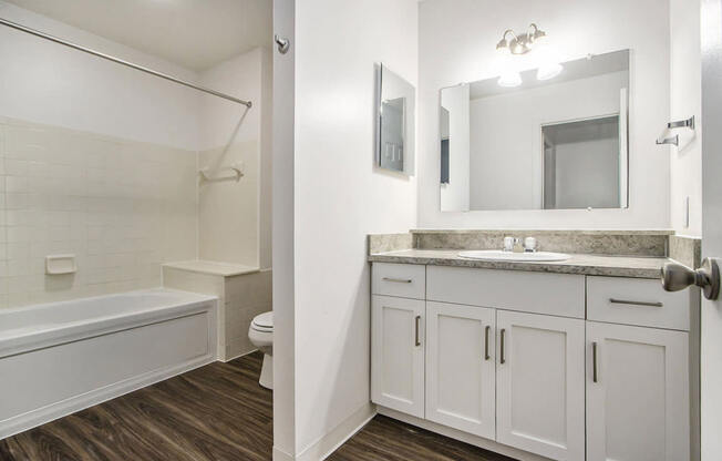A white bathroom with a soaking tub, toilet, and sink at Foxwood and The Hermitage, Portage, MI, 49024