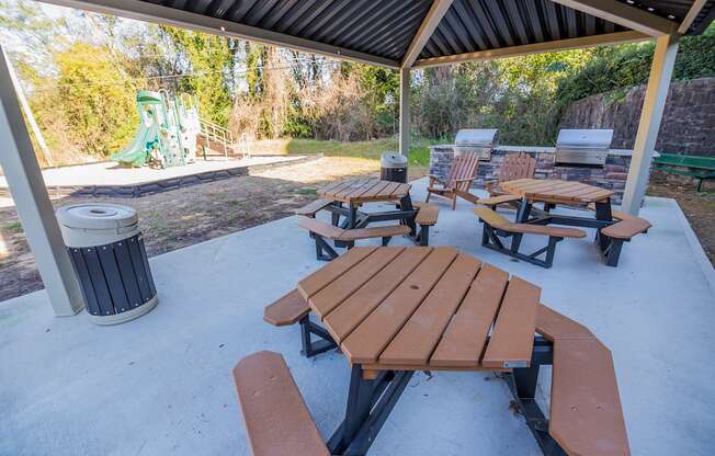 our picnic tables are under the pavilion with a playground in the background at Broadway at East Atlanta, Atlanta