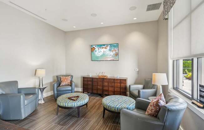 A living room with grey chairs and a painting on the wall.