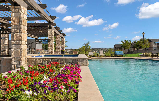 a swimming pool with flowers on the side of a building
