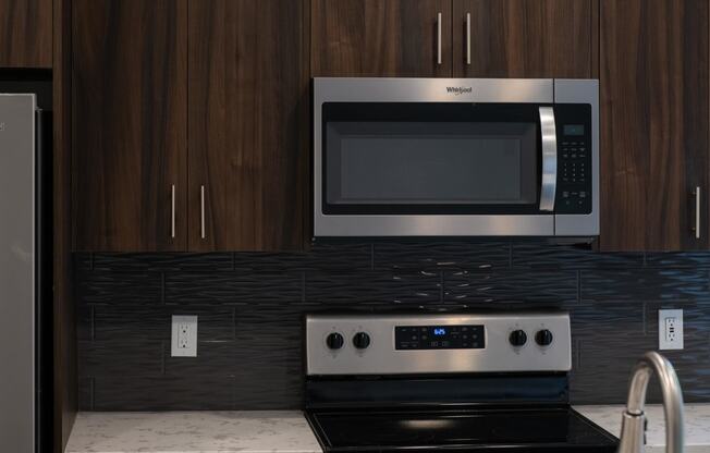 a kitchen with a stove and a microwave at The Clearing at ONE28, Olathe, Kansas