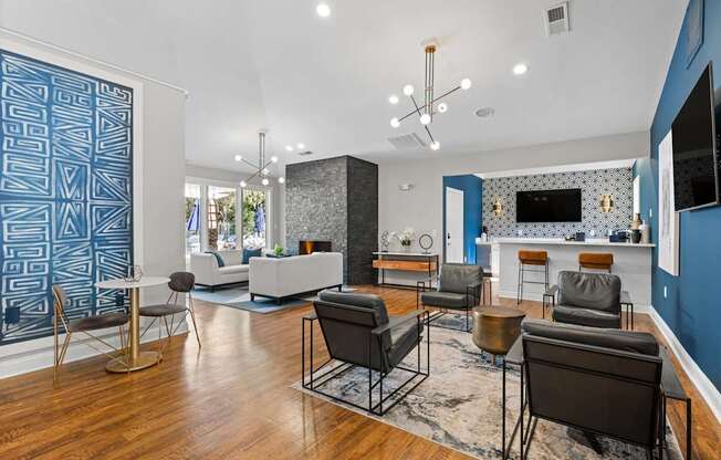 A living room with a blue accent wall and a patterned blue wallpaper.