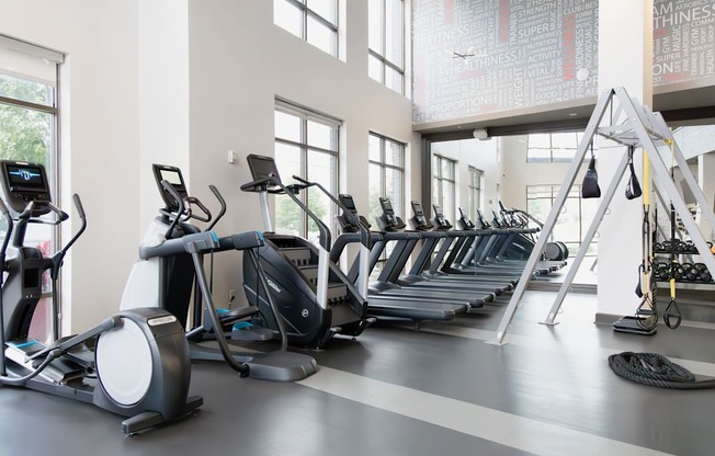 a row of cardio machines in a gym