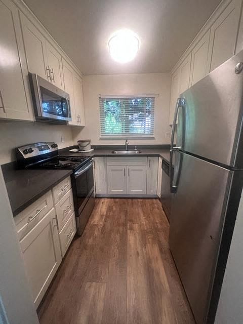 a small kitchen with a stainless steel refrigerator