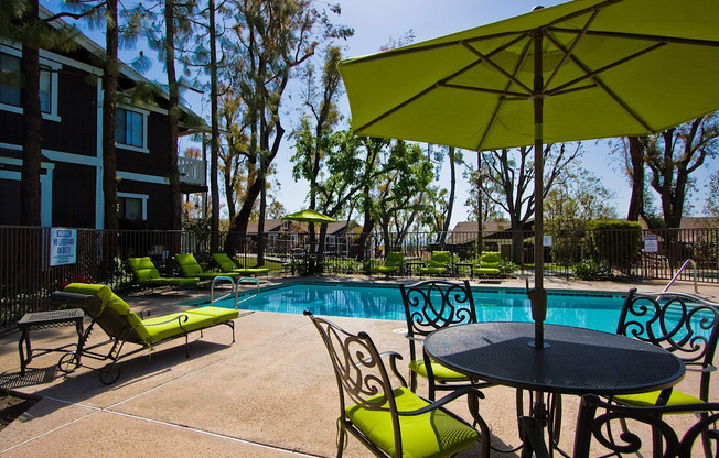 our apartments have a pool and patio with chairs and umbrellas