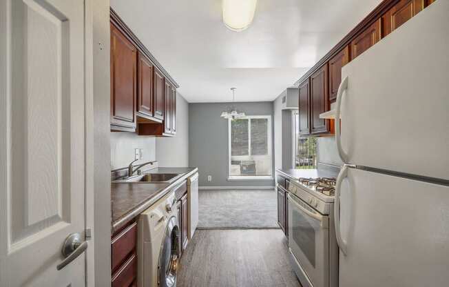 a kitchen with white appliances and wooden cabinets