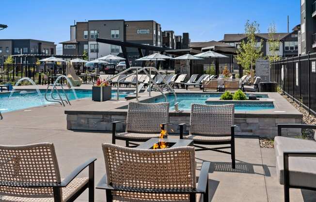 a swimming pool with chairs and tables next to a hotel pool