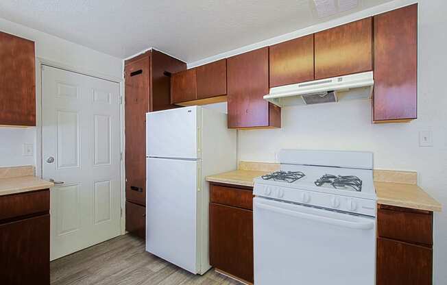 a kitchen with white appliances and wooden cabinets