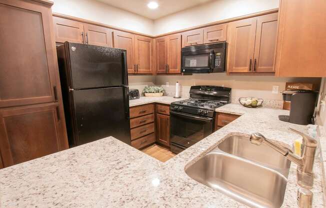 a kitchen with black appliances and granite counter tops