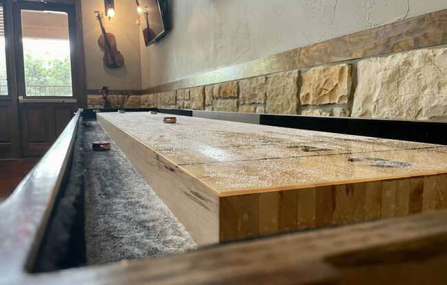 a bar with a concrete countertop and wood beams on the wall