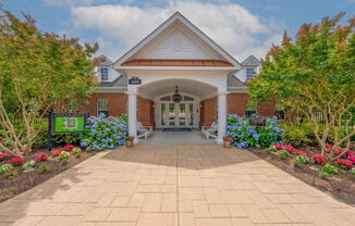 entrance to Fenwyck Manor Clubhouse with neat walkway and lush, mature landscaping