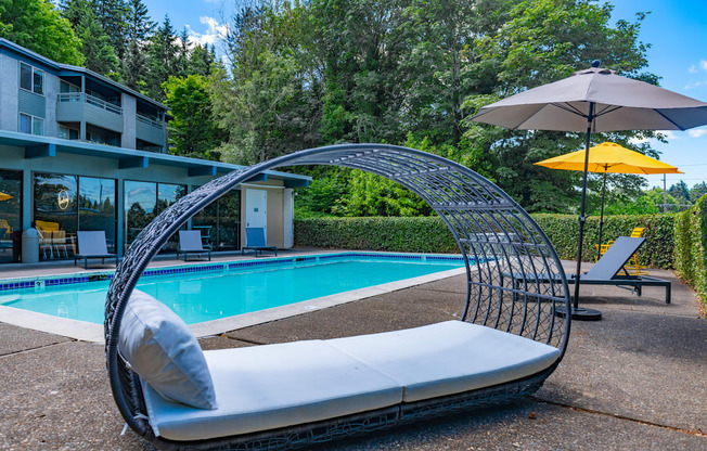 a lounge chair next to a pool in front of a building