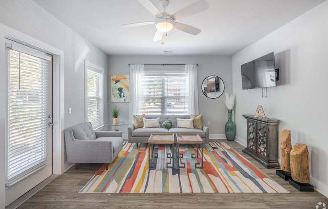a living room with a ceiling fan and a rug