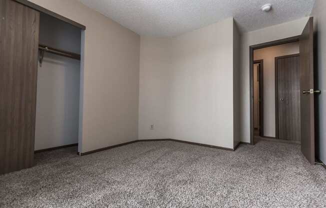 Grand Forks Primrose Apartments a small bedroom with two doors and a carpeted floor