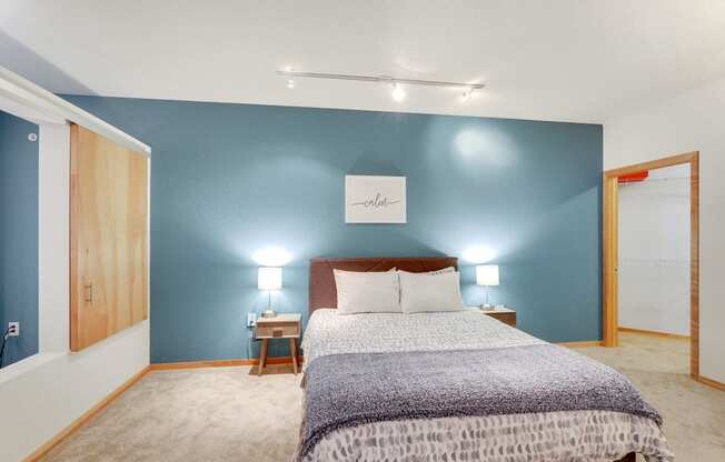 a room with a bed and a table and geometric patterns on the wall