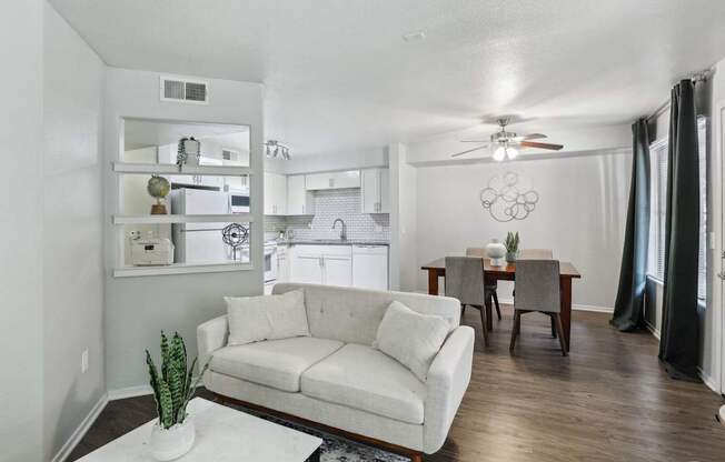 A living room with a white couch and a ceiling fan.
