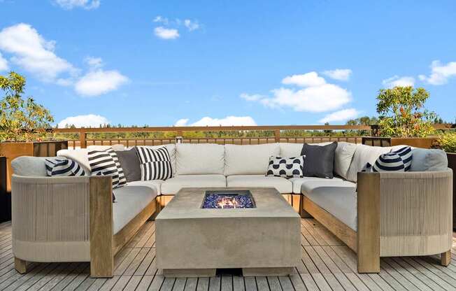 A wooden deck with a white couch and pillows.