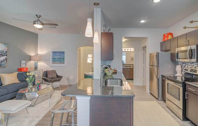 A modern kitchen with a dining area and a living room.