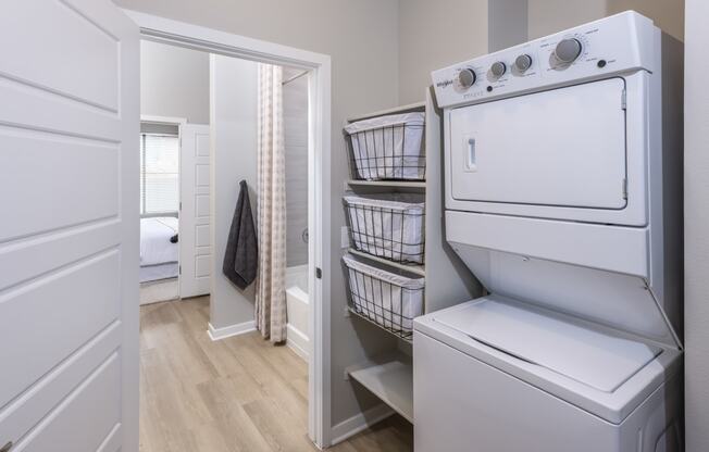 Icon at Cooley Station-apartment laundry room with a washer and dryer and a door to a bedroom